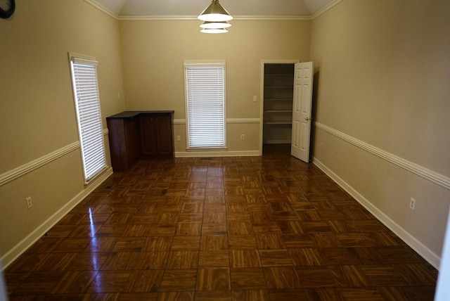 spare room featuring lofted ceiling, plenty of natural light, and baseboards