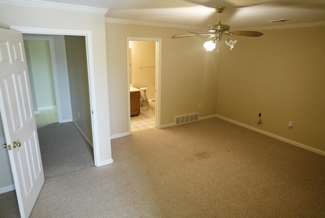 spare room with baseboards, visible vents, crown molding, and light colored carpet