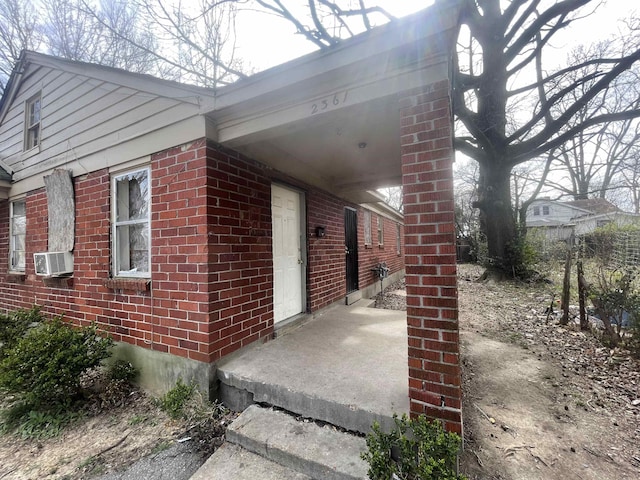 view of side of home featuring cooling unit and brick siding