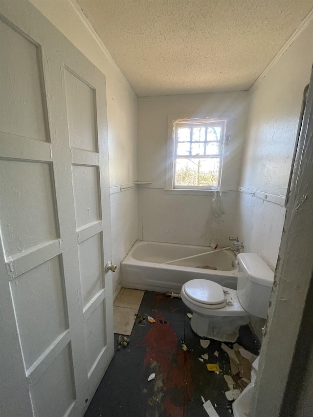 full bathroom featuring a textured ceiling, a bathing tub, and toilet