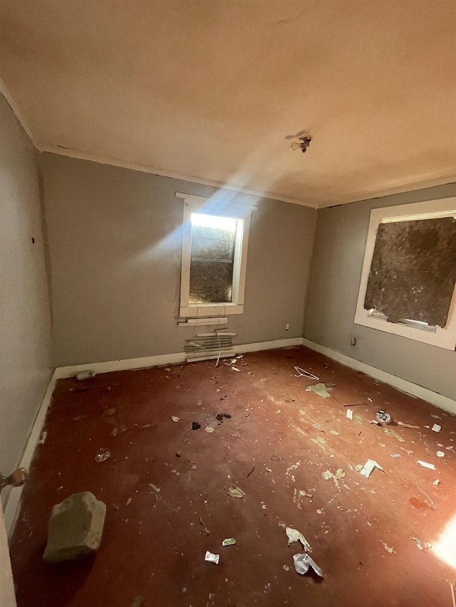 empty room featuring vaulted ceiling and baseboards