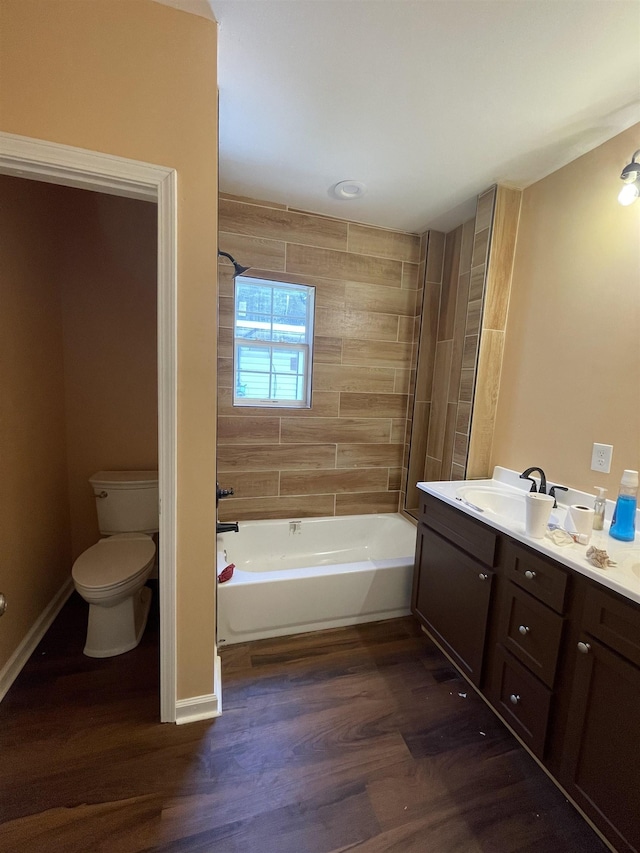 bathroom with shower / tub combination, toilet, wood finished floors, vanity, and baseboards