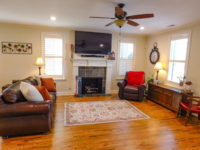 living area with visible vents, wood finished floors, crown molding, a fireplace, and recessed lighting