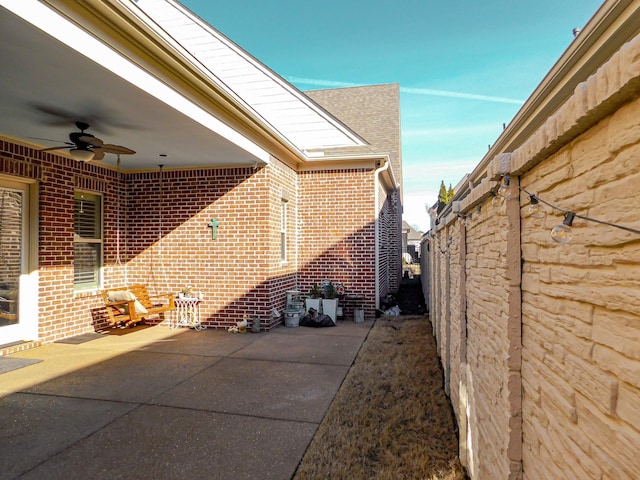 view of patio with fence and a ceiling fan