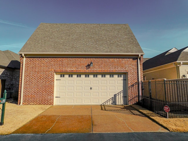 garage featuring fence and driveway