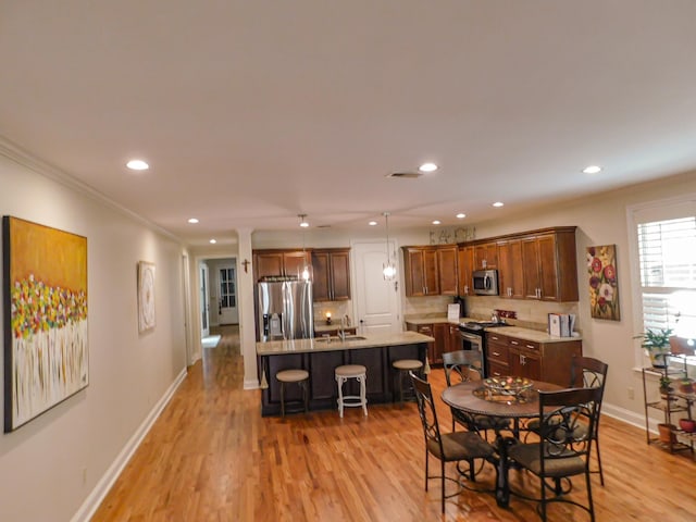 dining room featuring ornamental molding, light wood-type flooring, baseboards, and recessed lighting