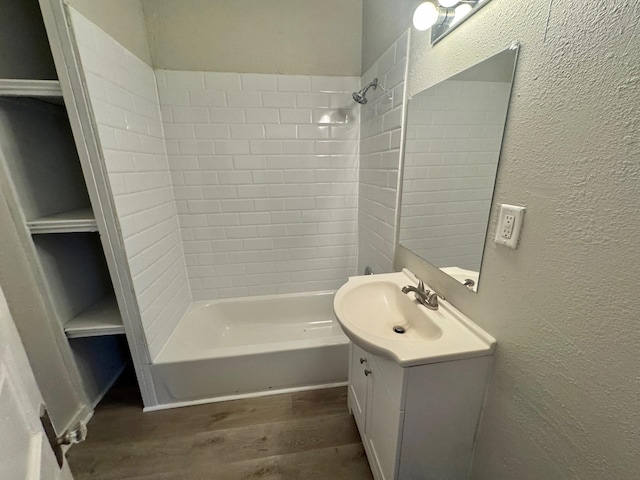 full bathroom featuring a textured wall, wood finished floors, and vanity