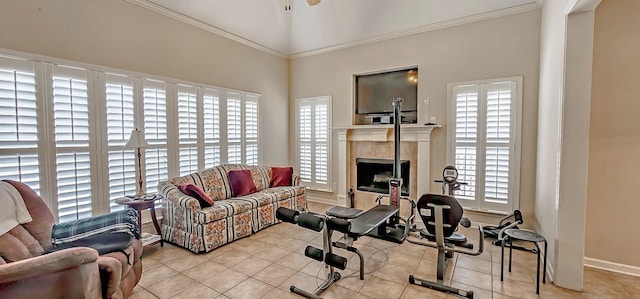 tiled living area with baseboards, ornamental molding, ceiling fan, and a tile fireplace