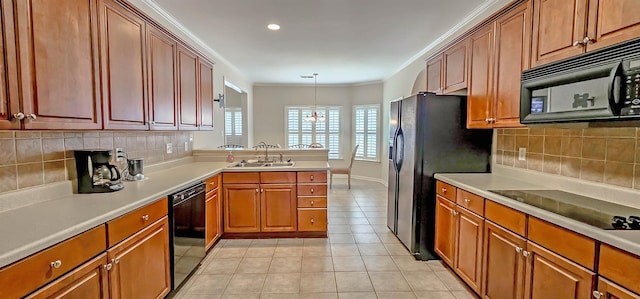 kitchen featuring light tile patterned floors, light countertops, crown molding, black appliances, and a sink