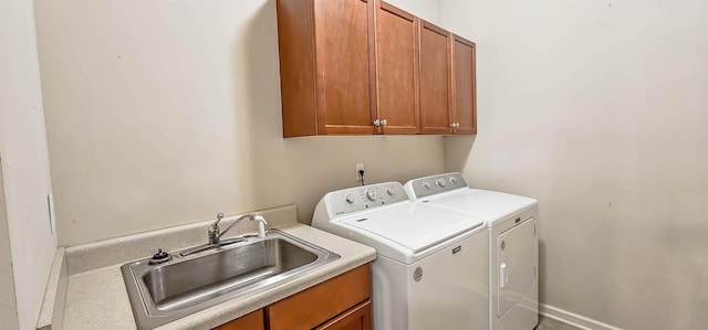 washroom featuring cabinet space, washer and clothes dryer, and a sink