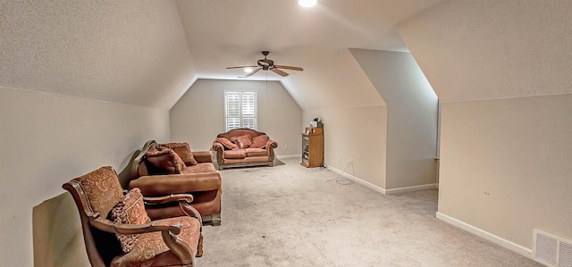 sitting room with carpet floors, baseboards, visible vents, and lofted ceiling