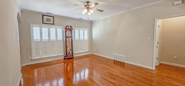 unfurnished room featuring wood-type flooring, visible vents, crown molding, and ceiling fan