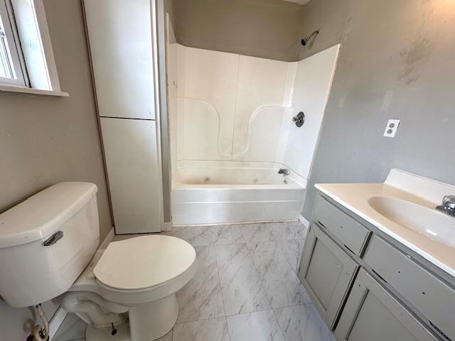 bathroom with toilet, marble finish floor, shower / washtub combination, and vanity