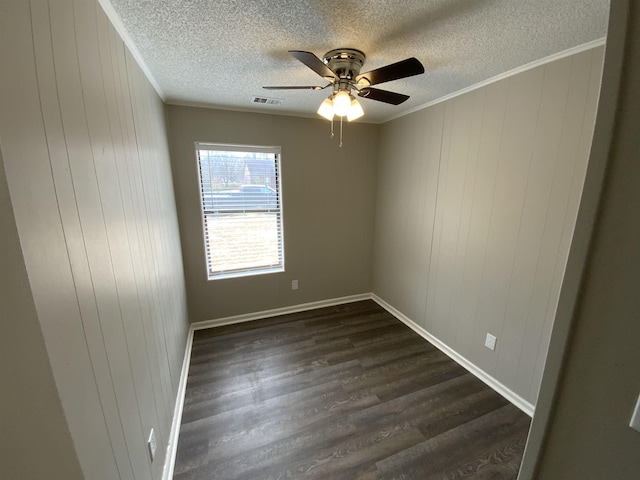 spare room with crown molding, visible vents, dark wood-type flooring, ceiling fan, and a textured ceiling