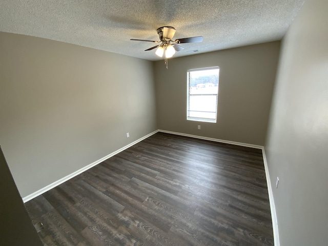 spare room with a ceiling fan, baseboards, and dark wood-style flooring