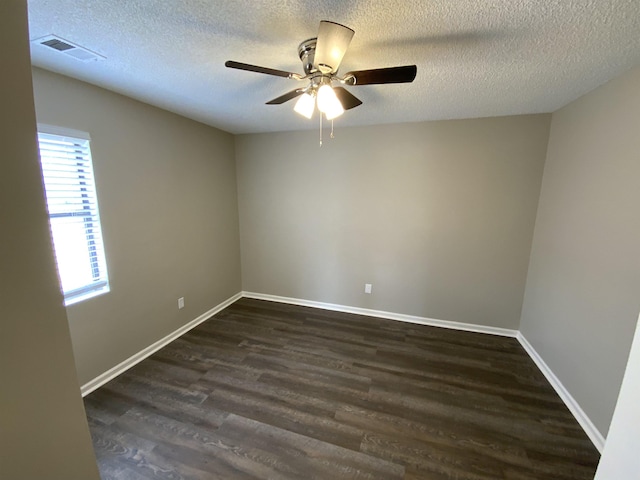 empty room with ceiling fan, a textured ceiling, visible vents, baseboards, and dark wood-style floors