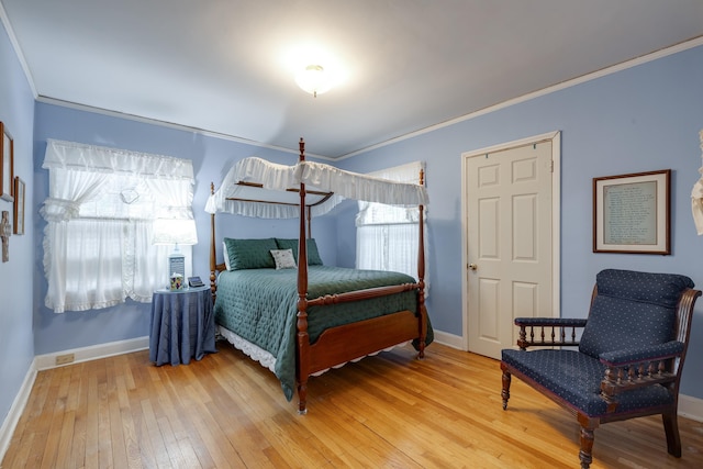 bedroom featuring crown molding, light wood-style flooring, and baseboards