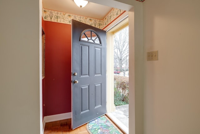 entryway featuring baseboards and wallpapered walls