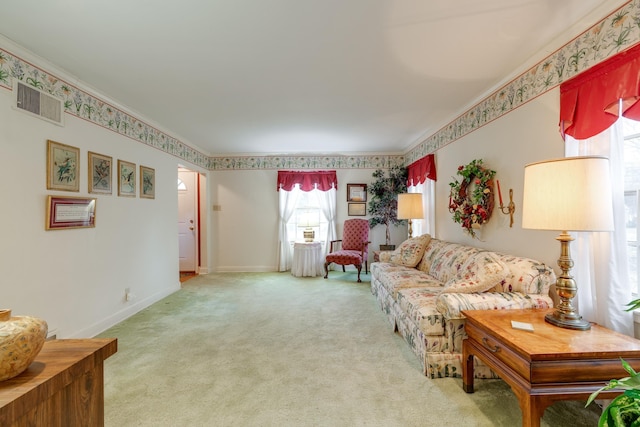 carpeted living room with wallpapered walls, ornamental molding, visible vents, and baseboards