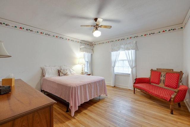 bedroom with light wood-type flooring, baseboards, and a ceiling fan