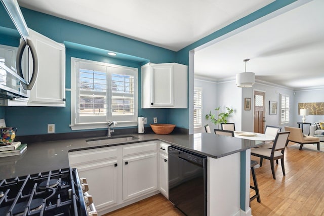 kitchen featuring appliances with stainless steel finishes, dark countertops, white cabinetry, and a sink