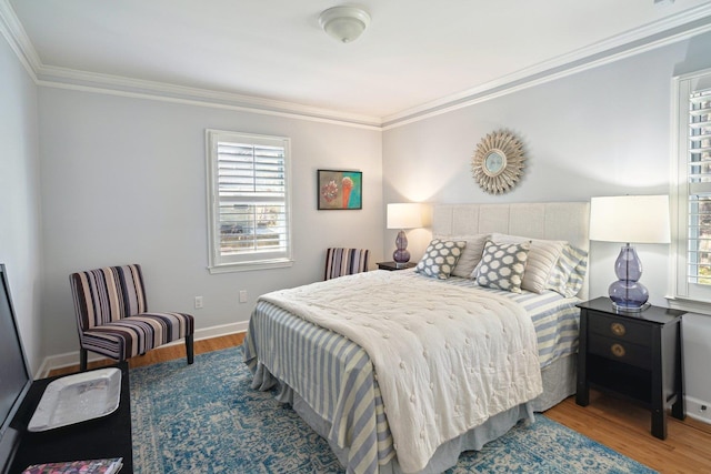 bedroom with ornamental molding, multiple windows, and wood finished floors