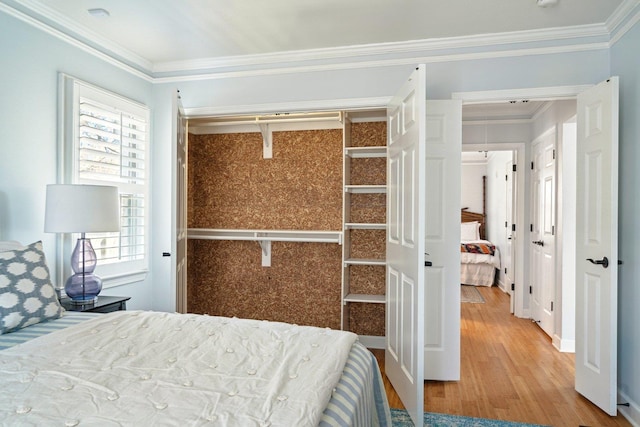 bedroom with crown molding and wood finished floors