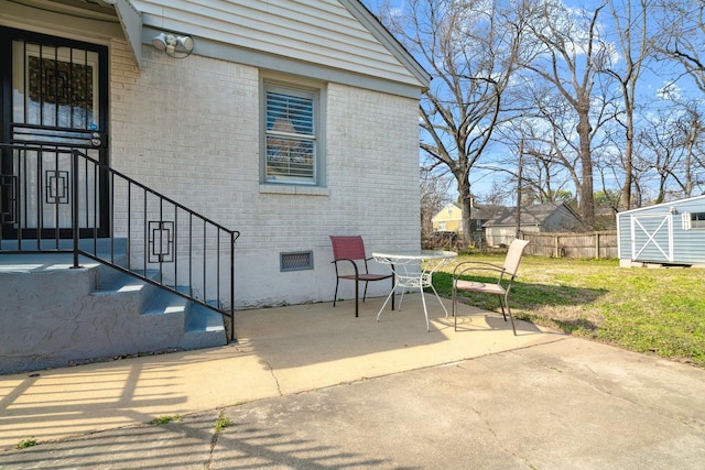 view of patio with an outbuilding and fence