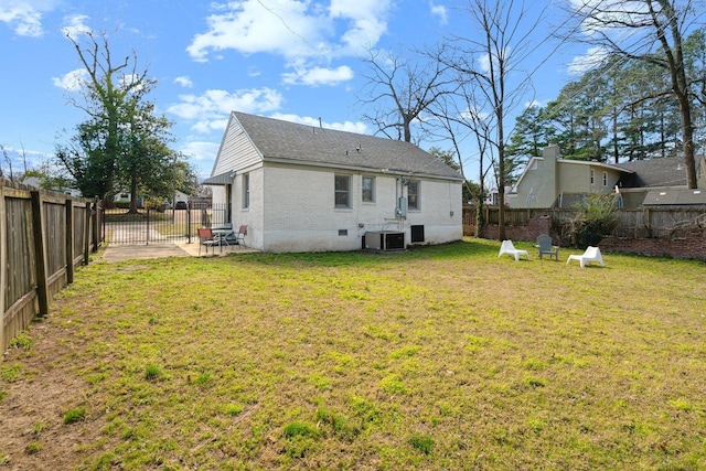 rear view of property featuring a fenced backyard, central AC, brick siding, a yard, and crawl space