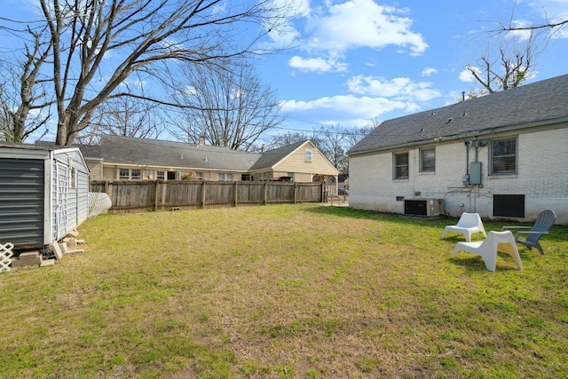 view of yard with fence, a storage unit, an outdoor structure, and central AC unit