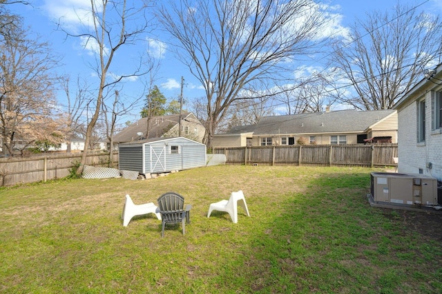 view of yard with central air condition unit, a fenced backyard, an outdoor structure, and a storage unit