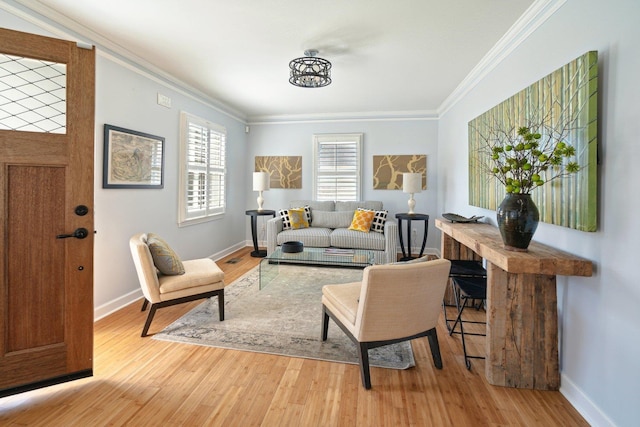 living area with light wood-style flooring, baseboards, and crown molding