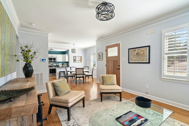 interior space with baseboards, ornamental molding, visible vents, and light wood-style floors