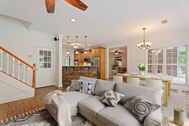 living area featuring visible vents, stairway, ornamental molding, ceiling fan with notable chandelier, and recessed lighting