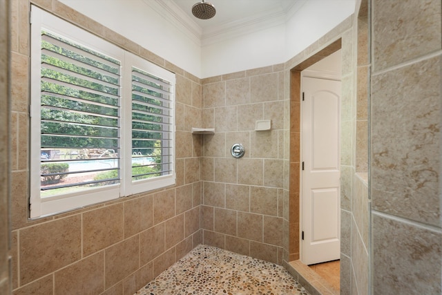 bathroom featuring a tile shower and crown molding