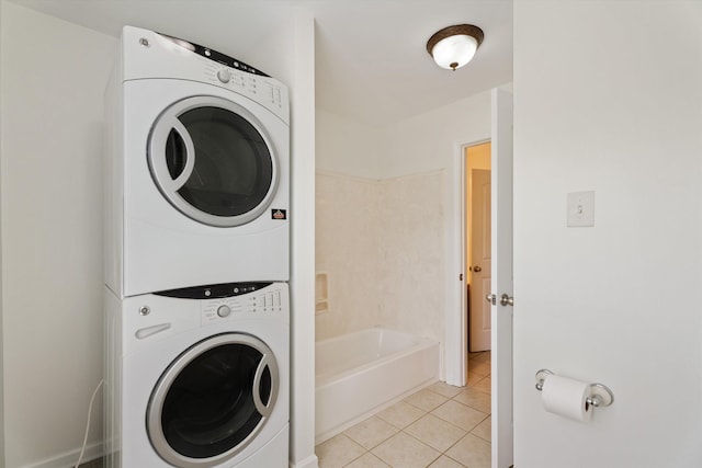 laundry area with laundry area, stacked washer / dryer, and light tile patterned flooring