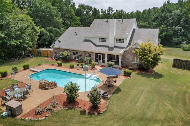 outdoor pool with a diving board, a lawn, a patio area, and a fenced backyard