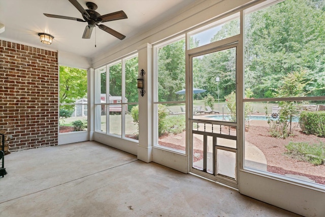 unfurnished sunroom with ceiling fan