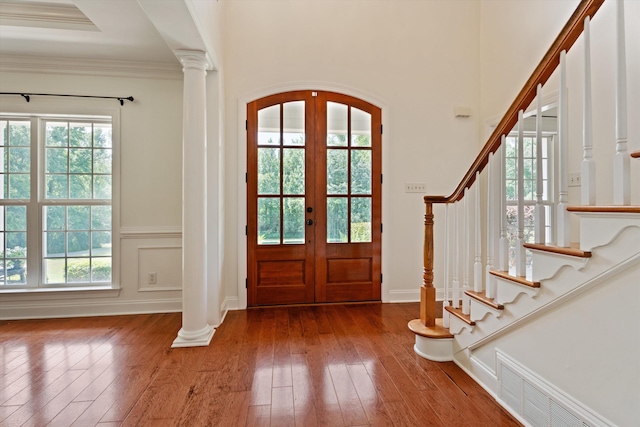 foyer with hardwood / wood-style flooring, decorative columns, visible vents, and french doors