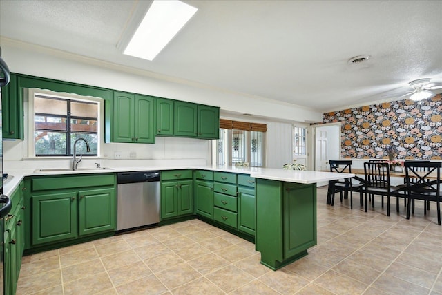kitchen featuring visible vents, stainless steel dishwasher, a sink, a peninsula, and wallpapered walls