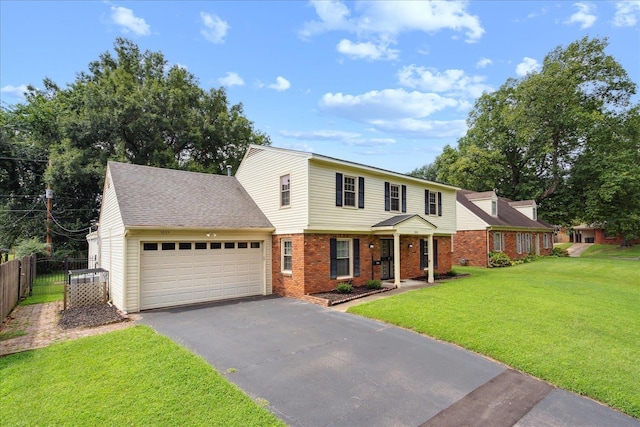 colonial inspired home with an attached garage, brick siding, fence, driveway, and a front yard