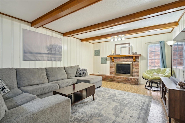 living room with a textured ceiling, brick floor, a fireplace, and beam ceiling