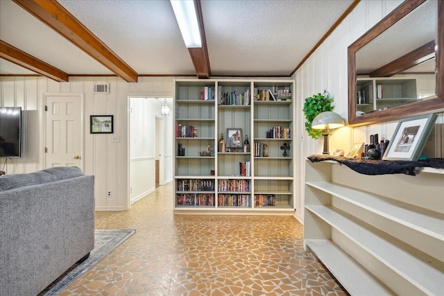 interior space with a textured ceiling, visible vents, beamed ceiling, and ornamental molding