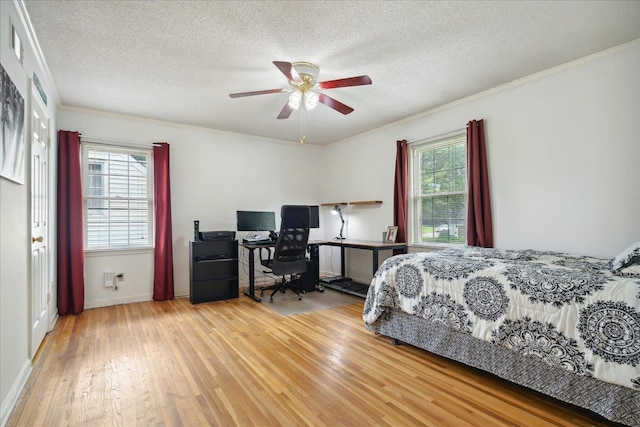 bedroom featuring a textured ceiling, wood-type flooring, multiple windows, and crown molding