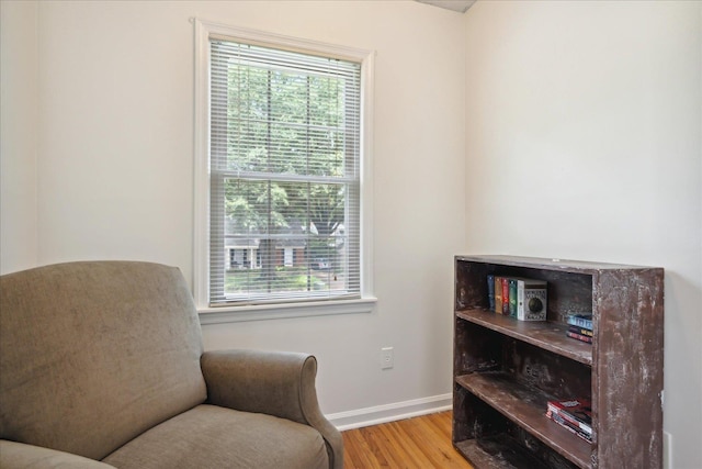 sitting room featuring a healthy amount of sunlight, baseboards, and wood finished floors