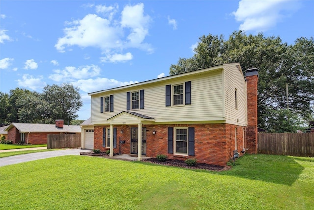 colonial house featuring driveway, fence, a front lawn, and brick siding