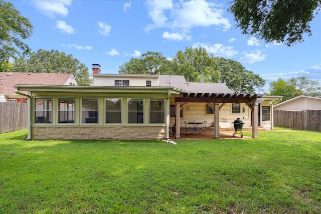 back of house featuring a chimney, a lawn, a patio area, and a fenced backyard