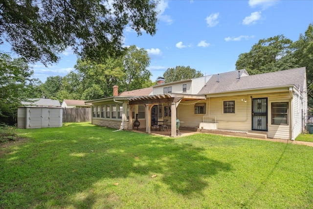 back of property featuring a lawn, fence, a storage unit, an outdoor structure, and a patio area