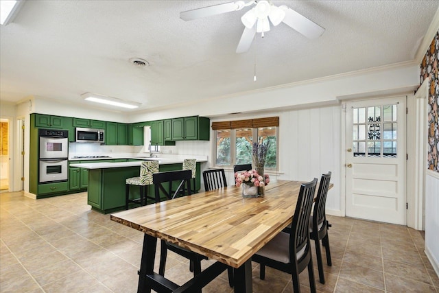 dining area featuring visible vents, crown molding, a textured ceiling, and light tile patterned floors