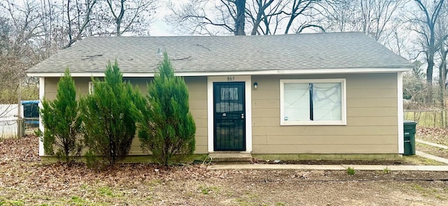 view of front of house with roof with shingles and fence